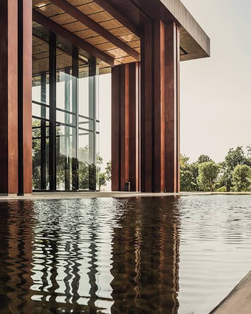 Venue facade reflected in the water feature by daylight